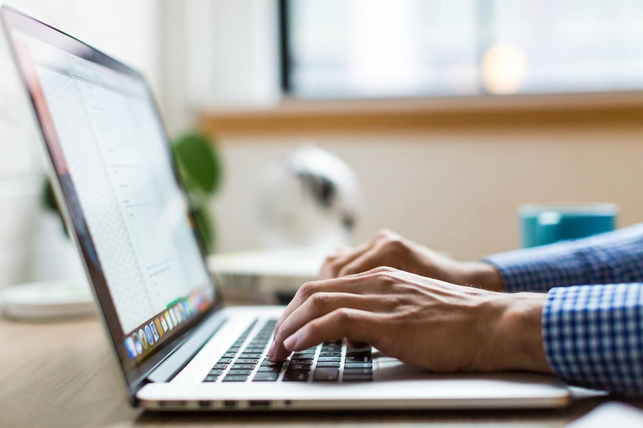 close up of hands typing on a laptop